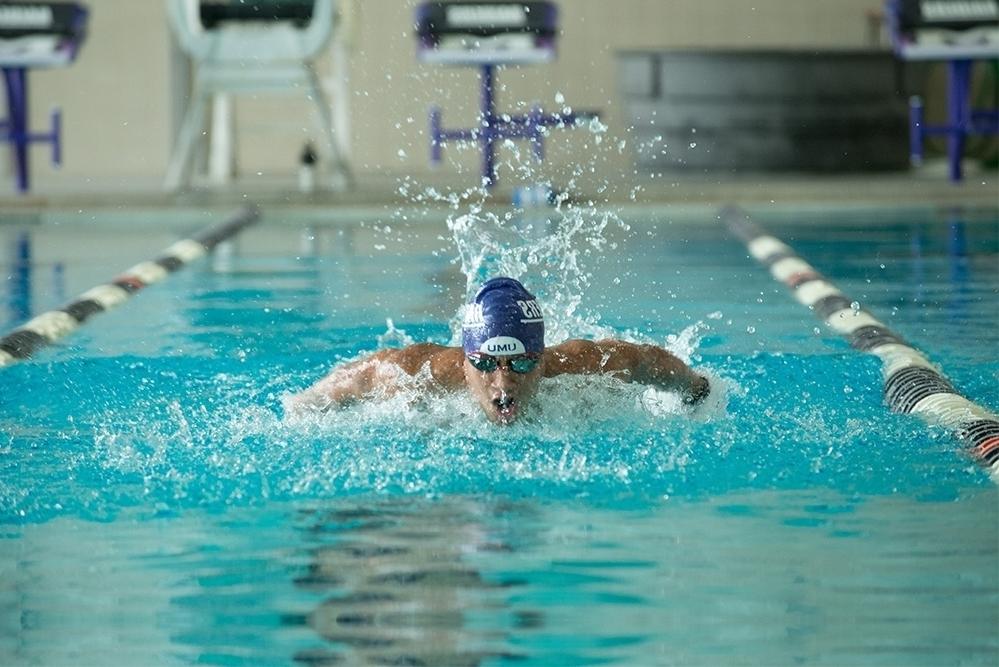 Male student swimming in pool